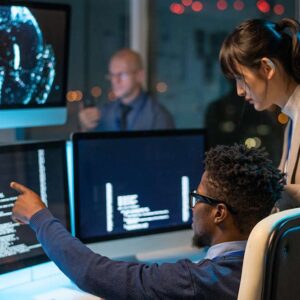 AI for DevOps: Developers collaborating on code. Team working with AI on multiple computer screens.
