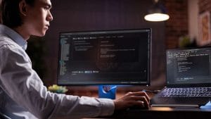 IT professional studying for CompTIA A+, Network+, and Security+ certifications. Man working on computer code.