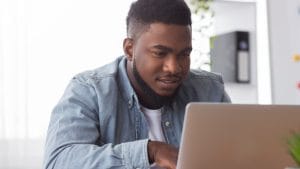 Geography student using laptop. Adult matric student studying online.