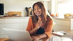 Setswana: Woman studying online. Adult matric home language course with laptop and notebook.