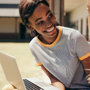 ICB Business Management student smiles with laptop. National Certificate: Small Business Financial Management.