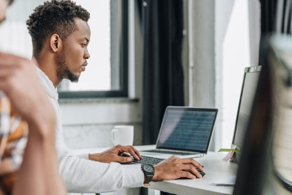 Oracle SQL Fundamentals training. Man using laptop, studying for 1Z0-071 exam. Database 12c R2 certification prep.