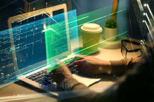 Ruby on Rails Full Stack Developer. Hands coding on laptop with code overlay. Software development, programming.