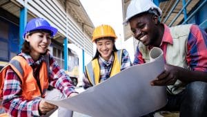NEBOSH International General Certificate in Occupational Health and Safety students. Construction workers reviewing plans.