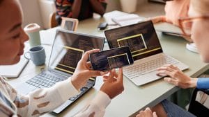 Interactive JavaScript site development: Developers working on code with laptops and mobile phone.