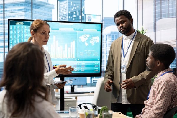 Information security leaders discuss data on screen. Business meeting.