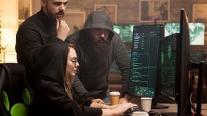 Introduction to Cybersecurity: Team analyzing code on computer screens. Cybersecurity experts working together.
