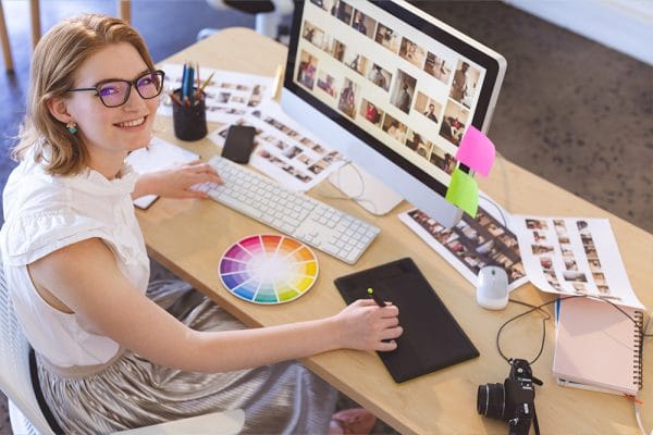 Learn visual design: Woman at desk with computer, color wheel, and graphic tablet. Visual design elements.