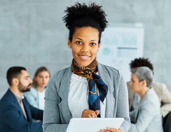 Confident office manager with tablet. Business meeting with diverse team. Office Manager Journey.
