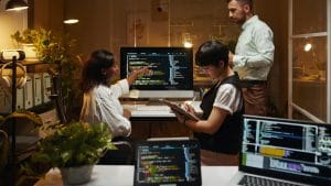 Security threat intelligence team analyzing code on computers. Cybersecurity experts collaborating on threat detection.