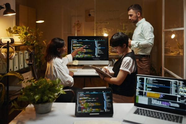 Security threat intelligence team analyzing code on computers. Cybersecurity experts collaborating on threat detection.