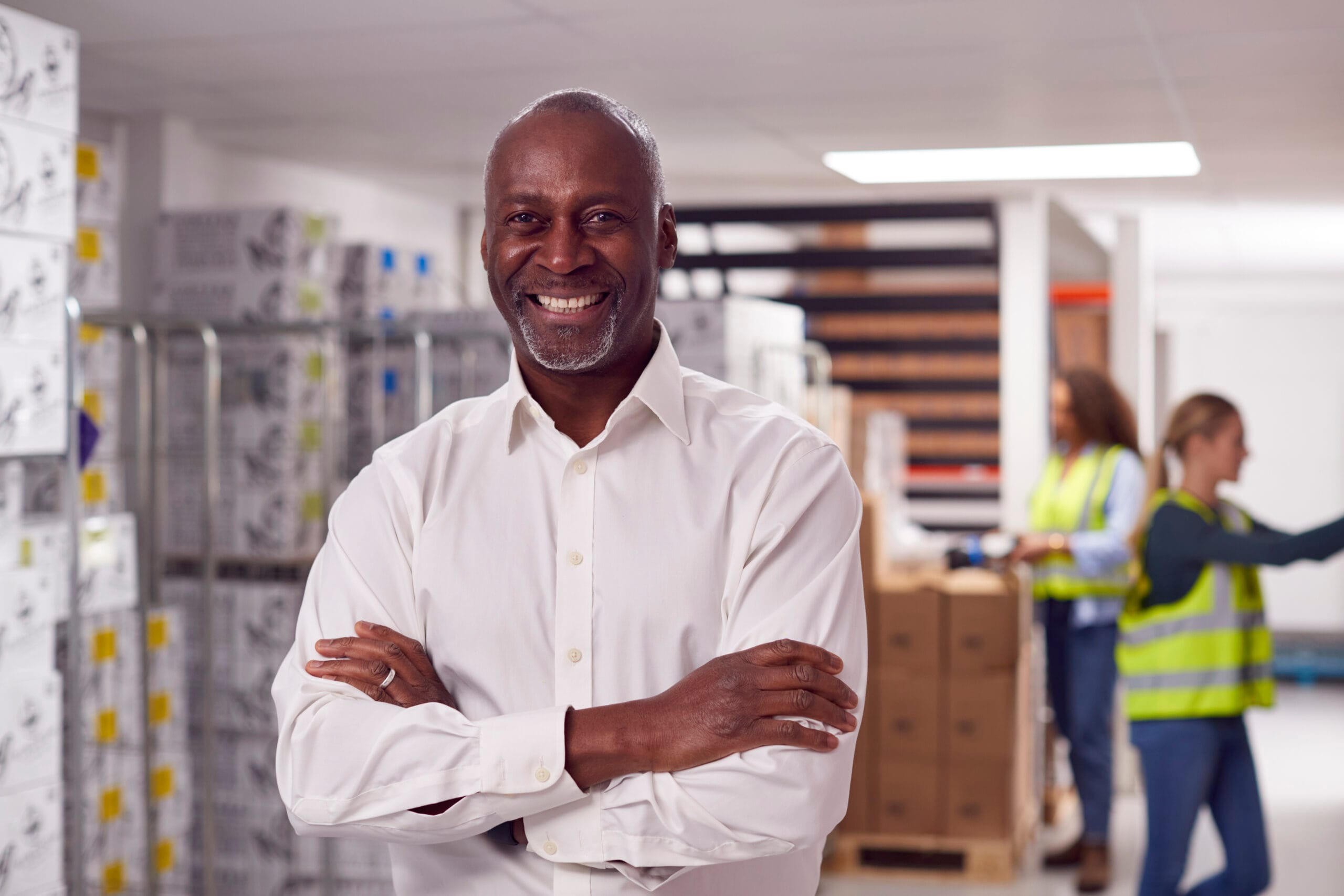 Smiling supply chain manager in warehouse. Logistics team, distribution, and inventory management.