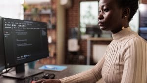 Woman coding Swift. Programmer at computer. Swift beginner to intermediate level.