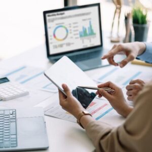 ICB Financial Accounting: Business professionals analyzing financial data on a tablet and laptop.