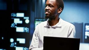 AWS Certified Solutions Architect Associate, man with laptop in server room.