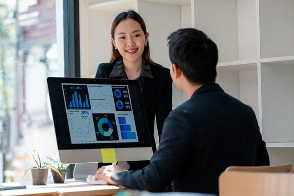Business Analyst to Data Analyst: Team analyzing data dashboards on a computer screen.
