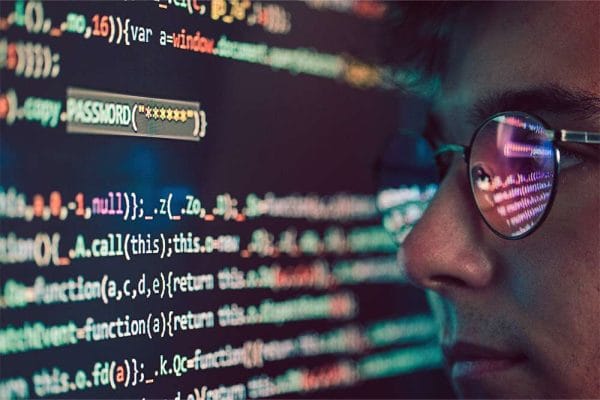 Cisco CyberOps Associate: Person with glasses looking at code. Cybersecurity professional, CBROPS certification.