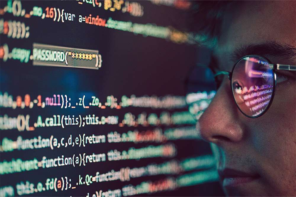 Cisco CyberOps Associate: Person with glasses looking at code. Cybersecurity professional, CBROPS certification.