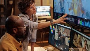 Communications Manager Journey: Team reviewing video editing software.