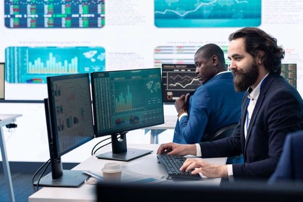 CompTIA Data+ professionals analyzing data on screens. Data analysis, charts, and graphs are visible.
