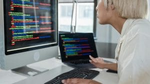CompTIA ITF+. Woman coding on computer. IT Fundamentals training for certification.