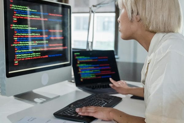 CompTIA ITF+. Woman coding on computer. IT Fundamentals training for certification.