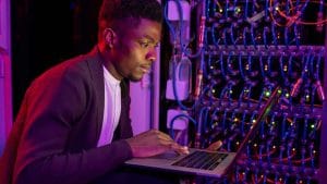 CompTIA A+ and Network+ certified IT professional working on a server with a laptop.