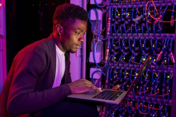 CompTIA A+ and Network+ certified IT professional working on a server with a laptop.