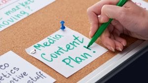 Content strategy planning on cork board. Hand writing Media Content Plan!.