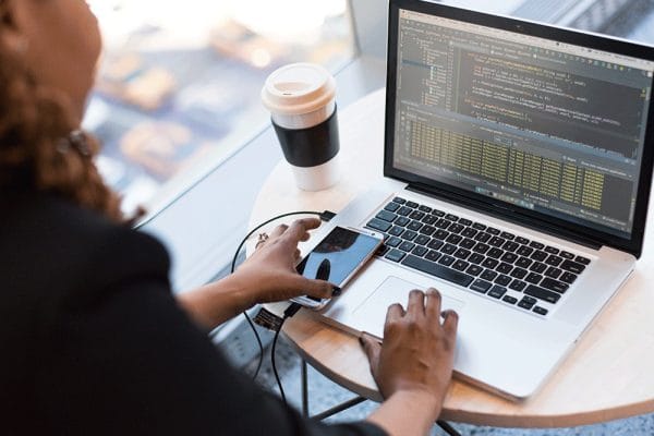 Microsoft DevOps solutions: Developer coding on laptop. Designing & implementing software with AZ-400.