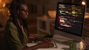 Enterprise developer working on DevOps. Woman coding on computer. Software engineer at desk.