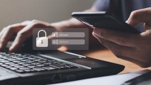 Ethical hacker using laptop and phone to access secure login. Cybersecurity concept.