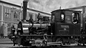 Vintage steam train Franzburg in black and white. History of rail transport. Antique locomotive with driver.