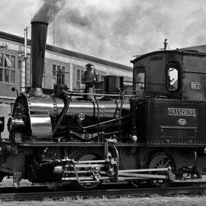 Vintage steam train Franzburg in black and white. History of rail transport. Antique locomotive with driver.
