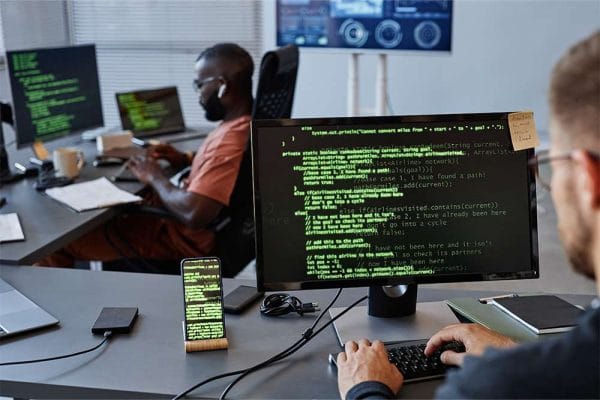 IT Professional at work. Developers coding on computers. Software development, cybersecurity.