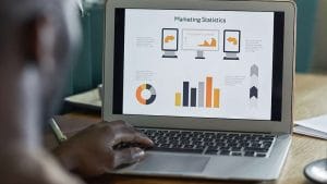 Marketing manager journey: Laptop displaying marketing statistics and infographics. Data analysis.