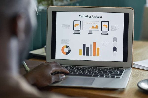 Marketing manager journey: Laptop displaying marketing statistics and infographics. Data analysis.