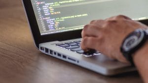 Azure Fundamentals (AZ-900): Person coding on a laptop. Learning Azure cloud computing.
