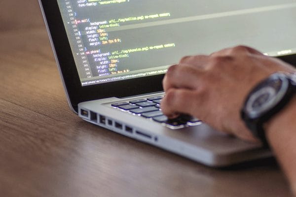 Azure Fundamentals (AZ-900): Person coding on a laptop. Learning Azure cloud computing.