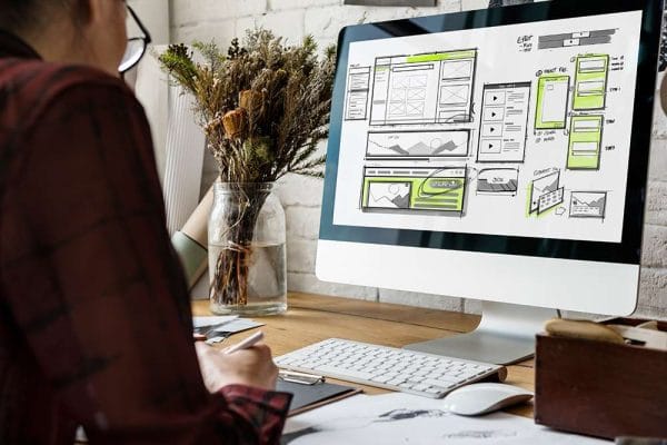 Web development basics. Designer working on website wireframe. Computer screen with website design.