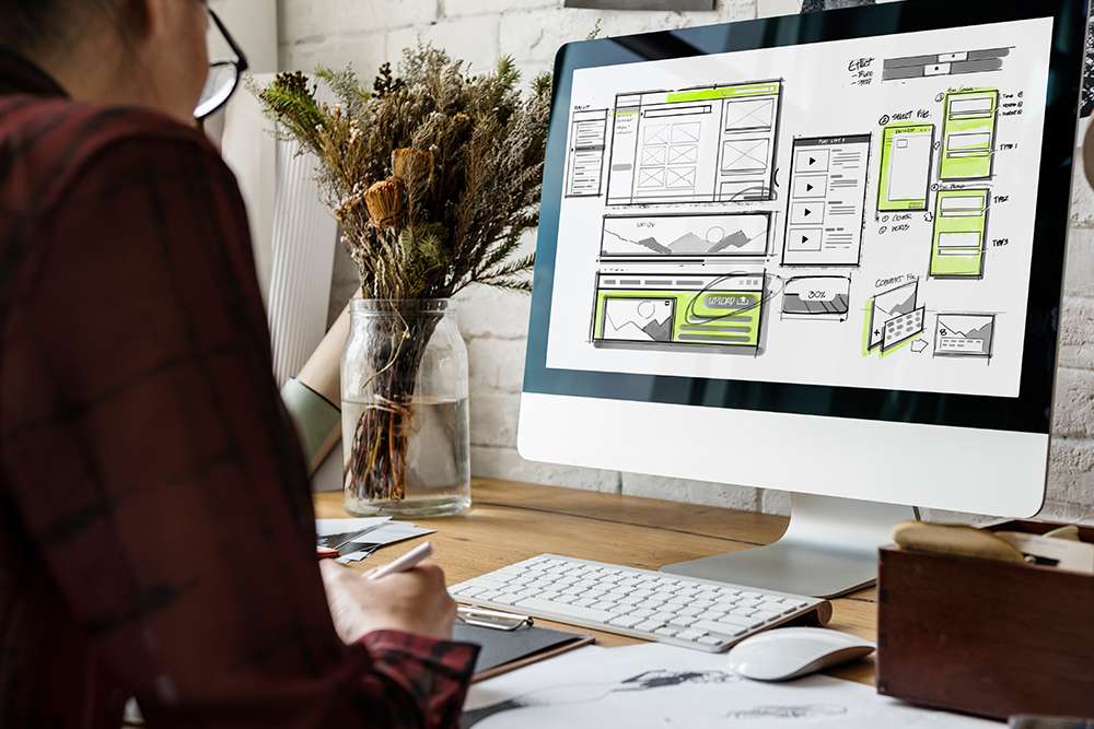 Web development basics. Designer working on website wireframe. Computer screen with website design.