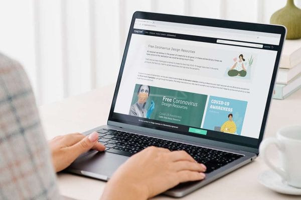 WordPress: Person using laptop. Screen displays Free Coronavirus Design Resources website.