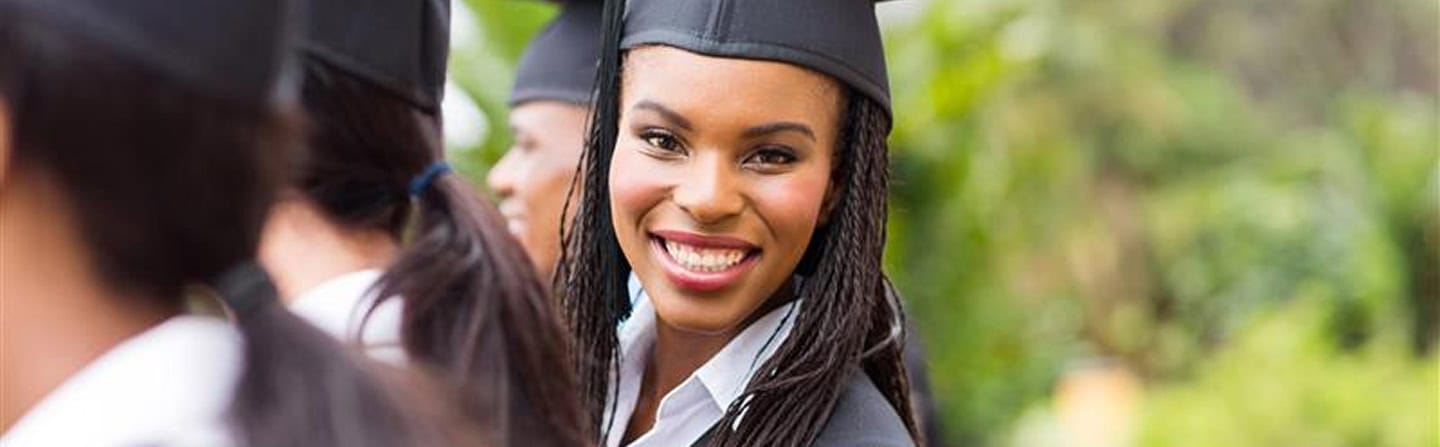 Smiling graduate in cap. Accredited college, university education.