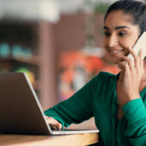 Adult education: Woman studies Setswana, using laptop and phone. Home language learning.