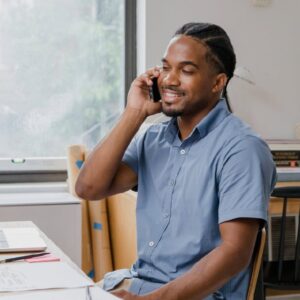 Man on phone. ICB Business Management student works from home. Higher Certificate in Office Administration.