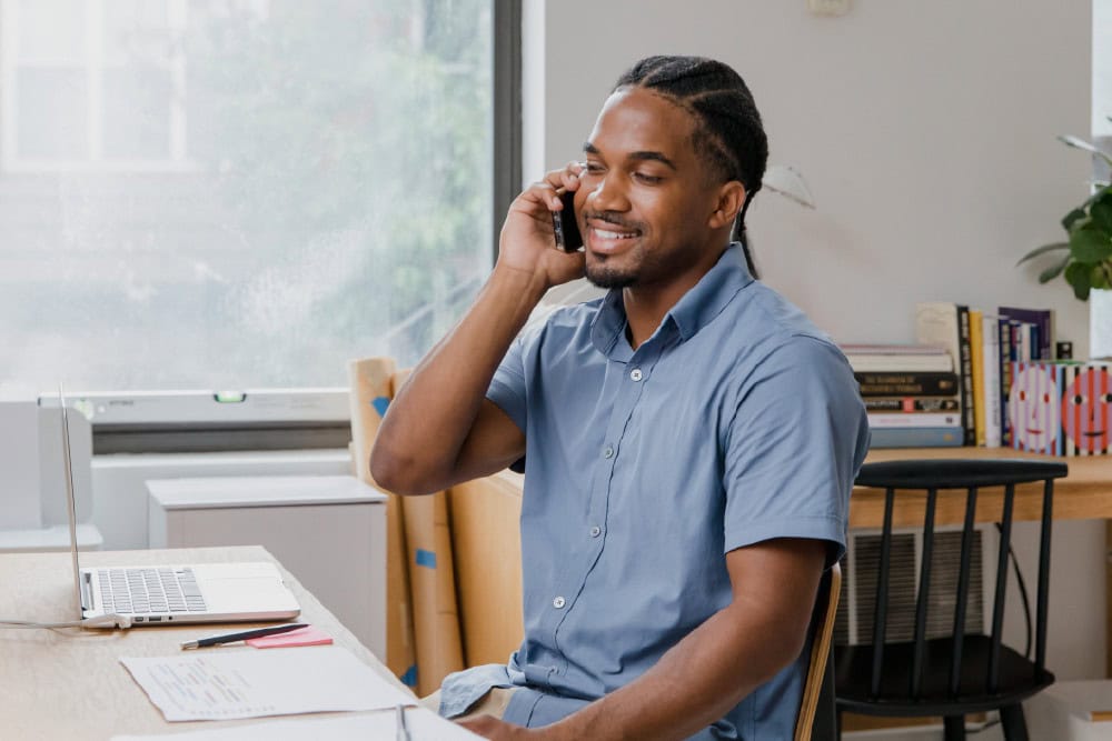 Man on phone. ICB Business Management student works from home. Higher Certificate in Office Administration.
